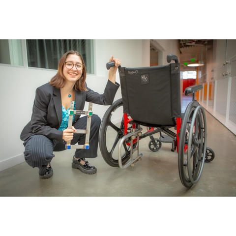 Harvard SEAS senior Zeynep Bromberg kneeling next to a manual wheelchair.