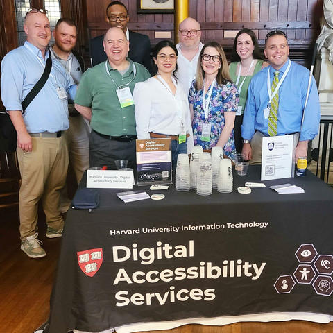 DAS staff behind a table that says Digital Accessibility Services. Left to right: Andy, John, Curtis, Evan, Suany, Derek, Janell, Jen, Kyle.